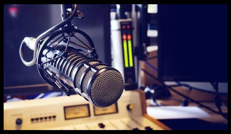 Micrófono de radio junto a una consola de sonido